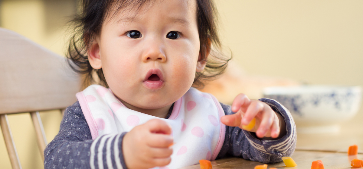 Baby eating in highchair